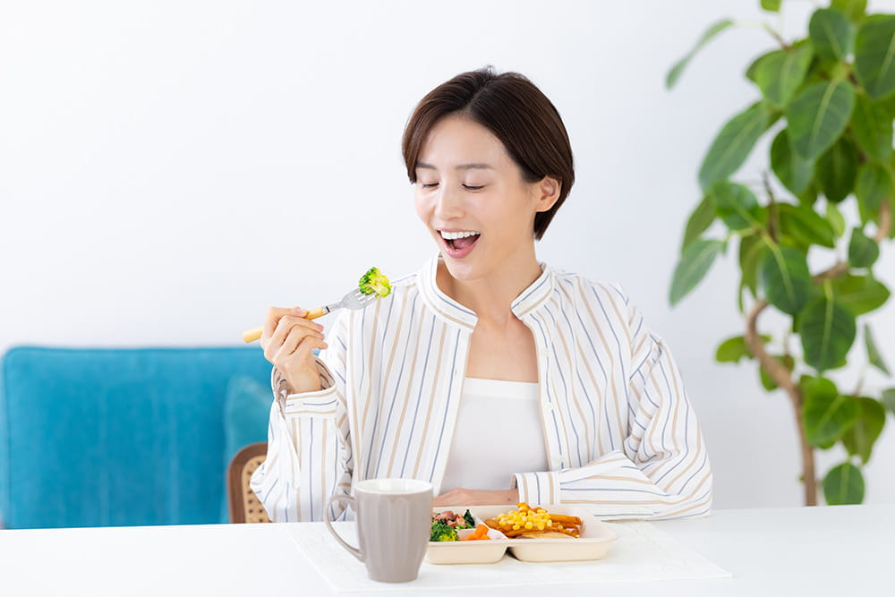 減塩宅配弁当を楽しむ女性